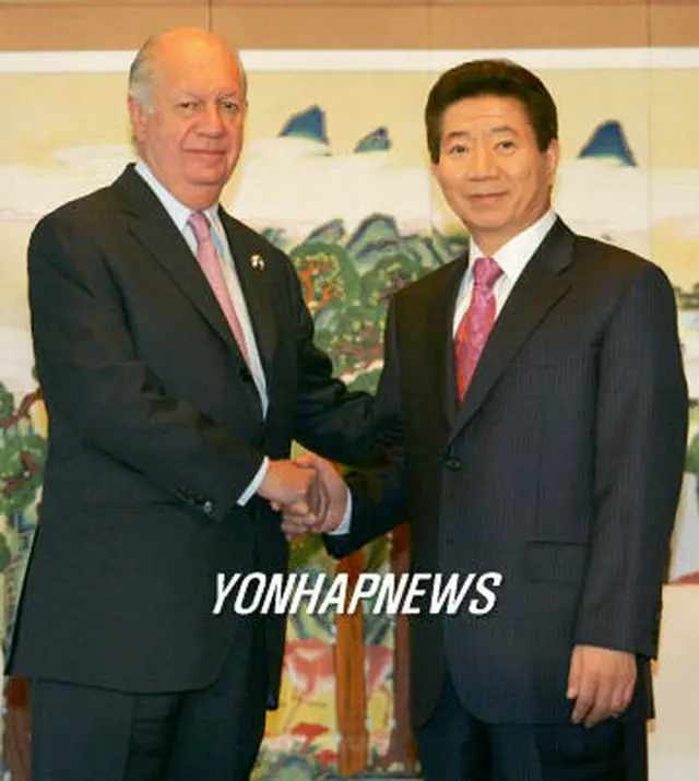 握手する盧大統領（右）とラゴス大統領＝１８日、釜山（聯合）