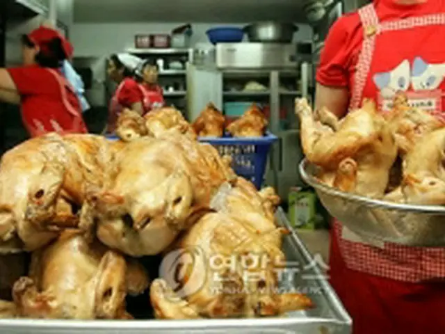 調理に追われるフライドチキン店の店員も韓国のチームカラー、赤いシャツ姿で＝（聯合ニュース）