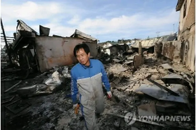 砲撃を受けた住宅地をぼう然とした表情で眺める島民＝24日、延坪島（国会写真記者団＝聯合ニュース）