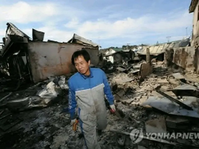 砲撃を受けた住宅地をぼう然とした表情で眺める島民＝24日、延坪島（国会写真記者団＝聯合ニュース）