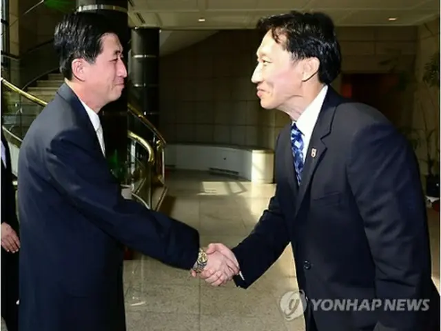 握手する韓国赤十字社の首席代表（右）と北朝鮮・朝鮮赤十字会の中央委員（韓国統一部提供）＝23日、ソウル（聯合ニュース）