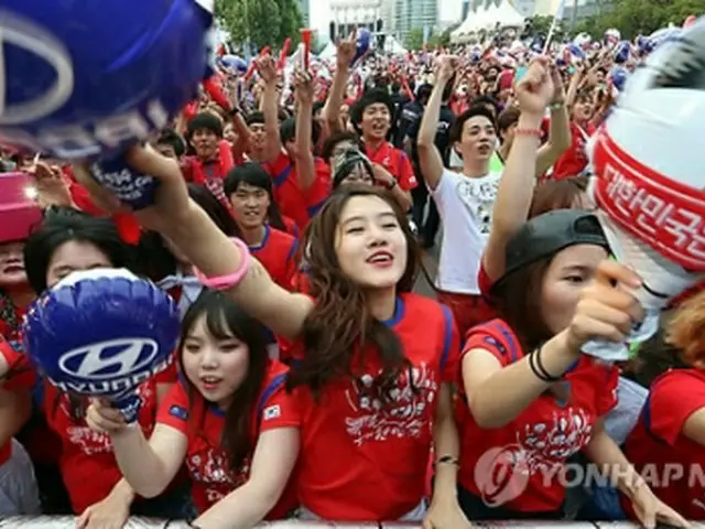 COEX前の永東大路交差点で街頭応援を行う韓国サポーター＝18日、ソウル（聯合ニュース）