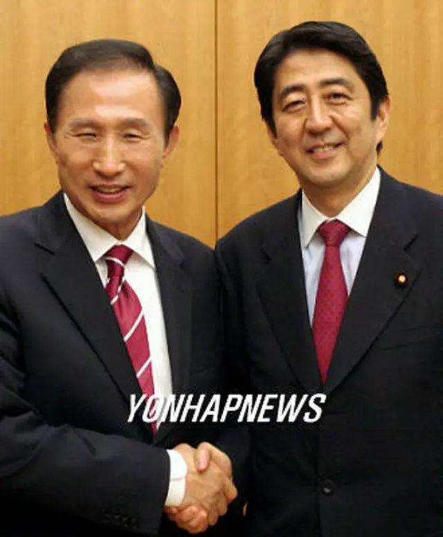 握手を交わす李明博前ソウル市長と安倍晋三首相＝10日、ソウル（聯合）