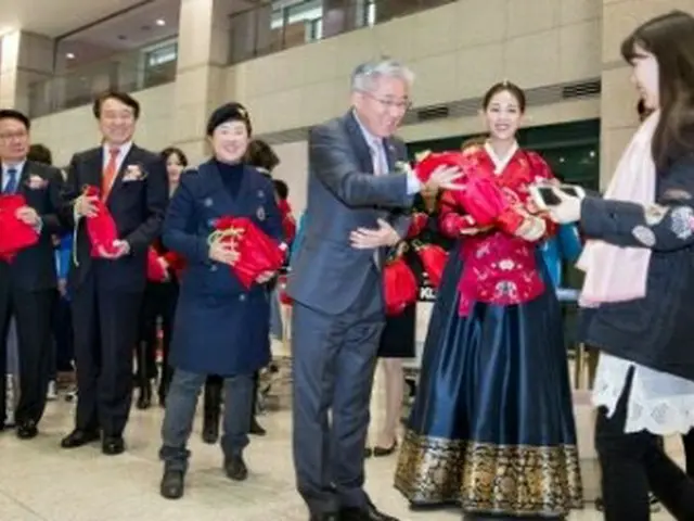 外国人客に韓国訪問の年の記念品を渡す金鍾徳長官＝１日、仁川（聯合ニュース）