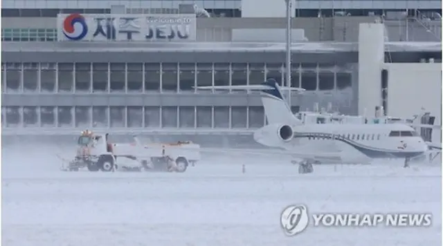 除雪作業が行われている済州空港の滑走路＝２４日、済州（聯合ニュース）