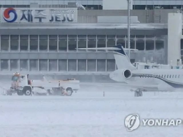 除雪作業が行われている済州空港の滑走路＝２４日、済州（聯合ニュース）