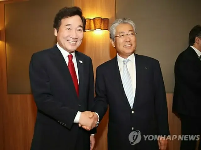 日本オリンピック委員会（ＪＯＣ）の竹田恒和会長（右）と握手を交わす李首相＝２４日、オリンピア（聯合ニュース）