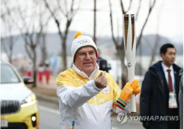 トーチを掲げるバッハ会長＝９日、平昌（聯合ニュース）