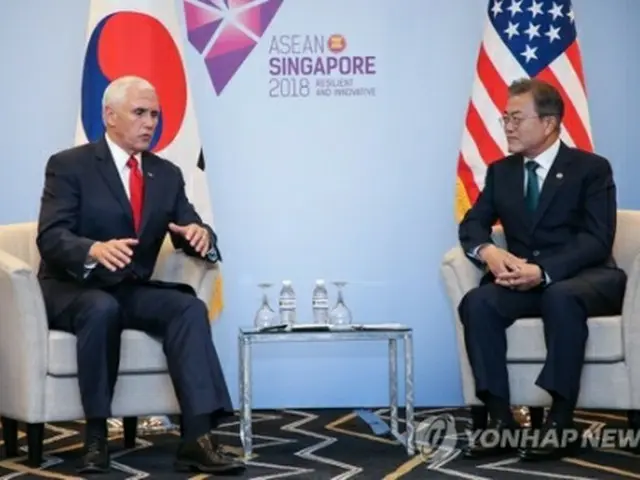 会談する文大統領（右）とペンス副大統領＝１５日、シンガポール（聯合ニュース）