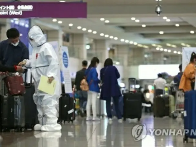 仁川国際空港で入国者を案内する防疫関係者＝（聯合ニュース）