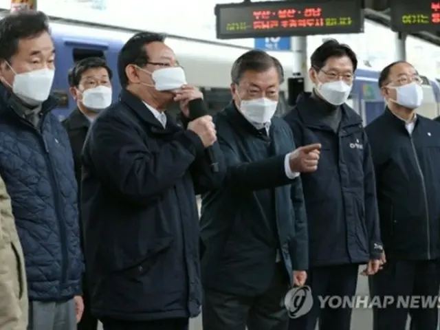 釜田駅で蔚山市の宋市長から報告を受ける文大統領（右から３人目）＝２５日、釜山（聯合ニュース）