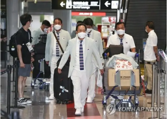 成田空港に到着した張仁華・選手団長（中央）＝１９日、成田（聯合ニュース）