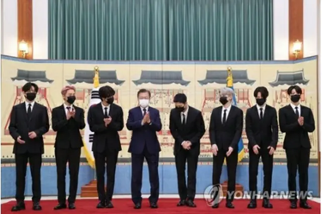 青瓦台で記念撮影を行う文大統領（左から4人目）とBTS＝14日、ソウル（聯合ニュース）