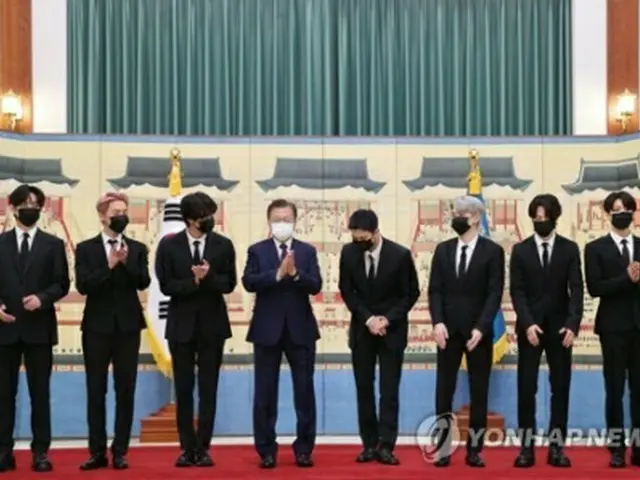 青瓦台で記念撮影を行う文大統領（左から4人目）とBTS＝14日、ソウル（聯合ニュース）