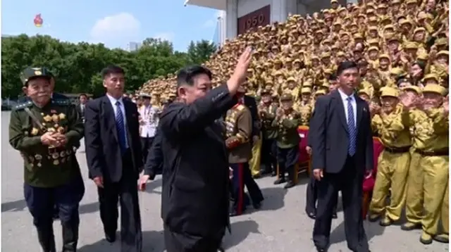 ２８日に開かれた全国老兵大会の参加者に手を振る金正恩氏。金氏のそばで警護員が警護に当たっている＝（朝鮮中央通信＝聯合ニュース）≪転載・転用禁止≫