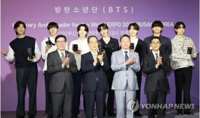 BTSは7月に、30年釜山万博誘致の広報大使に就任した。委嘱式で記念撮影するBTS（後列）と朴市長（前列左端）ら関係者（資料写真）＝（聯合ニュース）