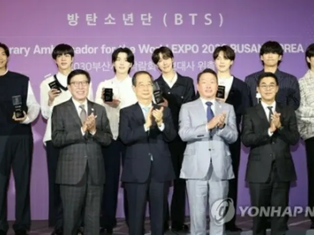 BTSは7月に、30年釜山万博誘致の広報大使に就任した。委嘱式で記念撮影するBTS（後列）と朴市長（前列左端）ら関係者（資料写真）＝（聯合ニュース）