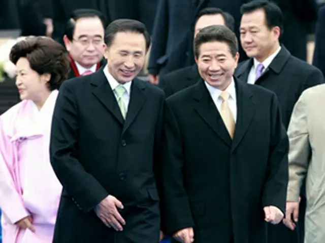 就任式終了後に李大統領（左）の見送りを受ける盧前大統領＝25日、ソウル（聯合）