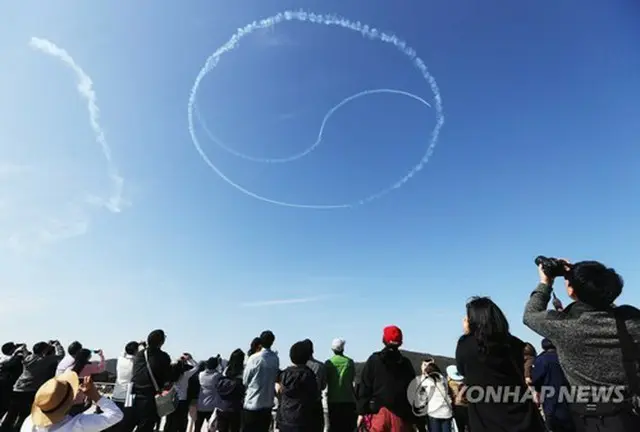 ２０１７年のＡＤＥＸで、韓国空軍特殊飛行チーム「ブラックイーグルス」の祝賀飛行を見上げる来場者（資料写真）=（聯合ニュース）