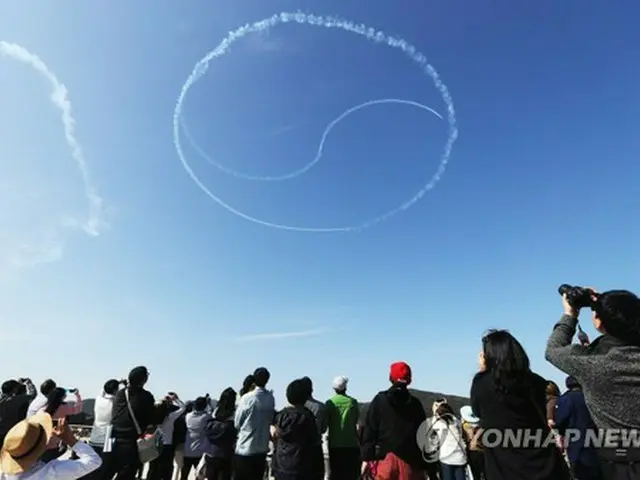 ２０１７年のＡＤＥＸで、韓国空軍特殊飛行チーム「ブラックイーグルス」の祝賀飛行を見上げる来場者（資料写真）=（聯合ニュース）