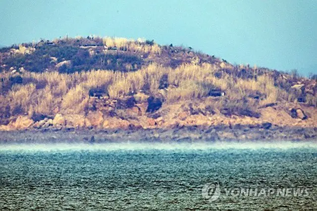 韓国・仁川の大延坪島から望む北朝鮮の長在島に砲門の姿が見える。北朝鮮が２０１８年の南北軍事合意の全面破棄を宣言して以降、朝鮮半島西側の黄海上の軍事境界線にあたる北方限界線（ＮＬＬ）にある海岸砲の砲門が開けられる事例が急増した。韓国軍当局によると、これまで北朝鮮軍が海岸砲の砲門を開けたのは１～２カ所だったが、近ごろは１０カ所以上に増えた＝２０２３年１１月２９日、仁川（聯合ニュース）