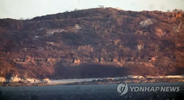 韓国・大延坪島の展望台から眺めた北朝鮮の大睡鴨島。複数の砲門が見える＝７日、延坪島（聯合ニュース）