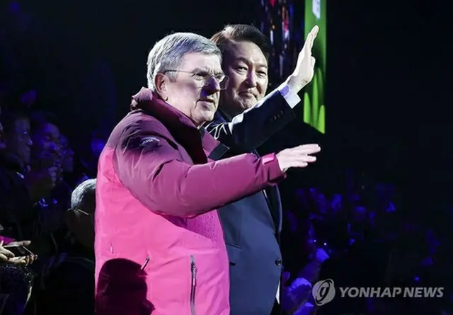 開会式で観衆に手を振る韓国の尹錫悦（ユン・ソクヨル）大統領（右）と国際オリンピック委員会（ＩＯＣ）のバッハ会長（大統領室通信写真記者団）＝１９日、江陵（聯合ニュース）