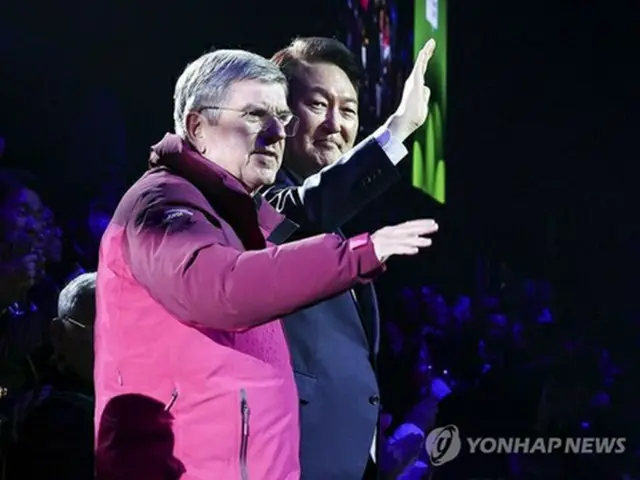 開会式で観衆に手を振る韓国の尹錫悦（ユン・ソクヨル）大統領（右）と国際オリンピック委員会（ＩＯＣ）のバッハ会長（大統領室通信写真記者団）＝１９日、江陵（聯合ニュース）