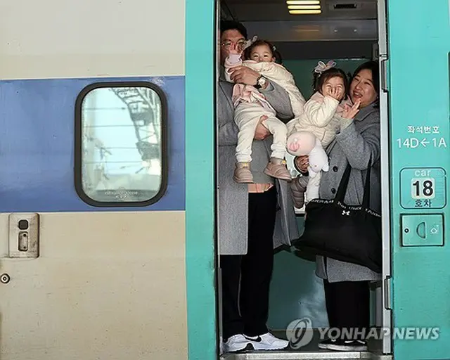 ソウル駅で列車に乗り込み、手を振る帰省客＝８日、ソウル（聯合ニュース）