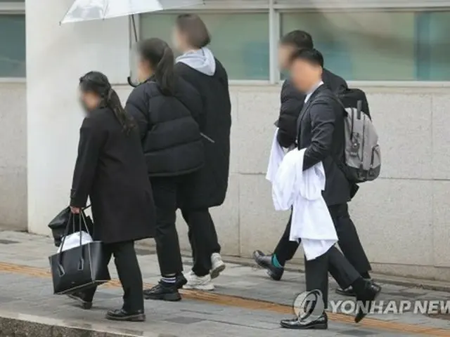 ソウル市内の大学病院で白衣を持って歩く関係者＝１９日、ソウル（聯合ニュース）