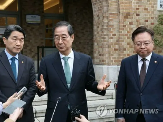 懇談会後、取材に応じる韓首相（中央）＝２６日、ソウル（聯合ニュース）
