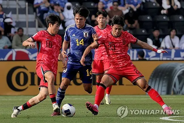 日本選手を囲む赤いユニホームの韓国の選手＝（聯合ニュース）