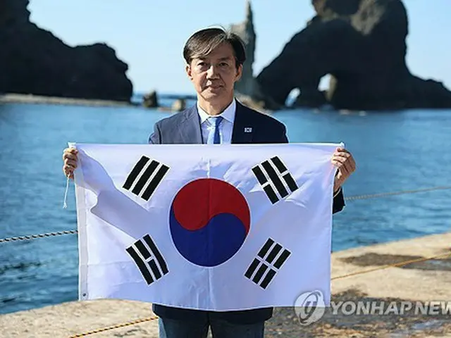 独島を訪れ、韓国国旗「太極旗」を手にする曺氏（同党提供）＝（聯合ニュース）≪転載・転用禁止≫