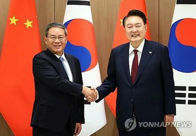 会談で握手を交わす韓国の尹錫悦大統領（右）と中国の李強首相（大統領室通信写真記者団）＝２６日、ソウル（聯合ニュース）