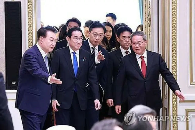 青瓦台（旧大統領府）で開かれた韓中日首脳会談に出席するため、会場に入る（左から）韓国の尹錫悦大統領、日本の岸田文雄首相、中国の李強首相＝２７日、ソウル（聯合ニュース）