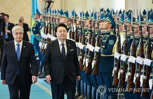 歓迎式典で儀仗隊による栄誉礼を受ける韓国の尹大統領（右）とカザフスタンのトカエフ大統領＝１２日、アスタナ（聯合ニュース）