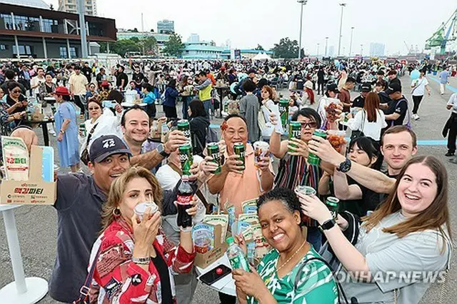 仁川港で５月に開かれたイベントでビールを楽しむ外国人観光客＝（聯合ニュース）