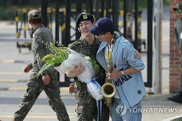 除隊したＪＩＮと笑顔であいさつを交わすＲＭ＝（聯合ニュース）