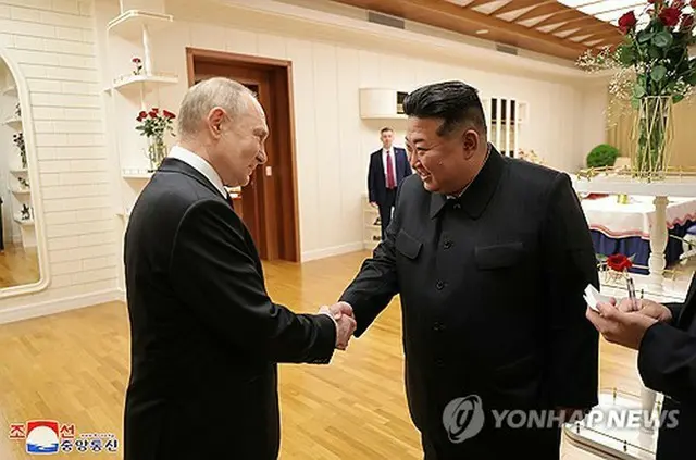 平壌に到着したプーチン氏（左）と握手する金正恩氏＝（朝鮮中央通信＝聯合ニュース）≪転載・転用禁止≫