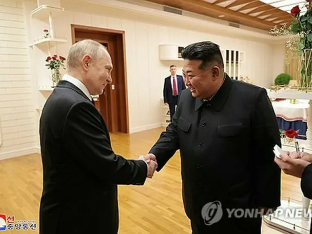 平壌に到着したプーチン氏（左）と握手する金正恩氏＝（朝鮮中央通信＝聯合ニュース）≪転載・転用禁止≫