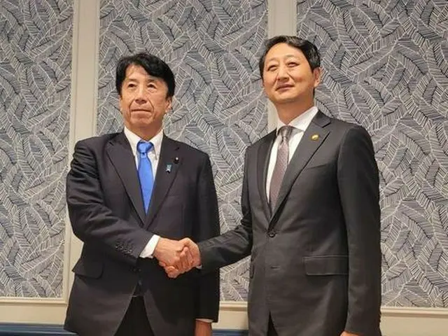 会談前、握手を交わす韓国の安徳根・産業通商資源部長官（右）と日本の斎藤健経済産業相＝２６日、ワシントン（聯合ニュース）