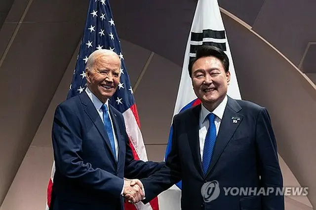 韓米首脳会談で握手する尹大統領（右）とバイデン米大統領（共同取材）＝１１日、ワシントン（聯合ニュース）