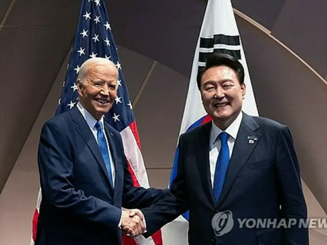 韓米首脳会談で握手する尹大統領（右）とバイデン米大統領（共同取材）＝１１日、ワシントン（聯合ニュース）