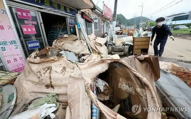 大雨に見舞われた完州郡内の商店前に廃棄物が山積みになっている＝１１日、完州（聯合ニュース）