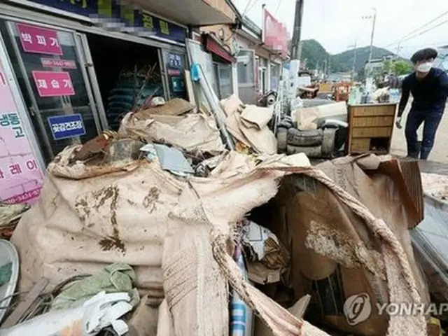 大雨に見舞われた完州郡内の商店前に廃棄物が山積みになっている＝１１日、完州（聯合ニュース）