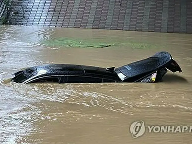 京畿道華城市で１８日、冠水した道路で車が水没している（華城市自律防災団提供）＝（聯合ニュース）≪転載・転用禁止≫