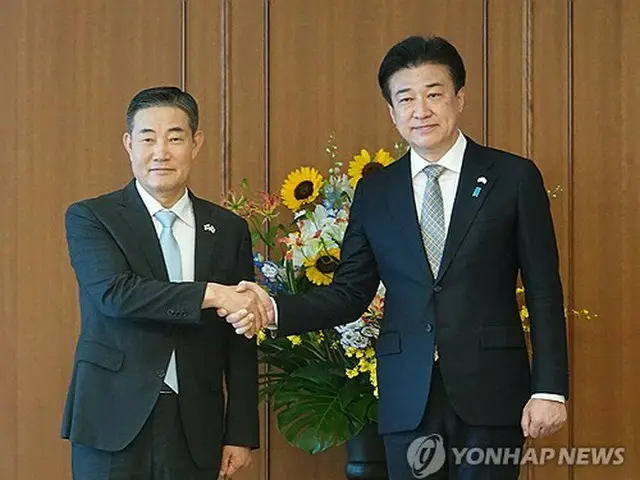 握手を交わす申源湜（シン・ウォンシク）国防部長官（左）と木原稔防衛相＝２８日、東京（聯合ニュース）