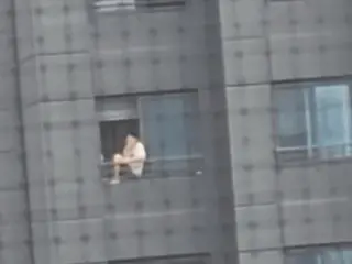 マンション20階の手すりに腰掛けてたばこを吸う男性が物議を醸す＝韓国
