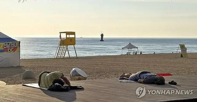 北東部・江陵の鏡浦海水浴場。熱帯夜を避けて海辺で涼を取る住民＝７日、江陵（聯合ニュース）