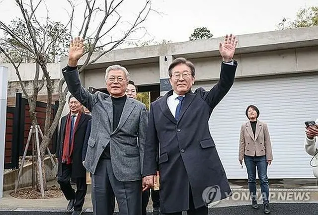 ２月２４日、文前大統領（左）の自宅を訪れた共に民主党の李代表（同党提供）＝（聯合ニュース）≪転載・転用禁止≫